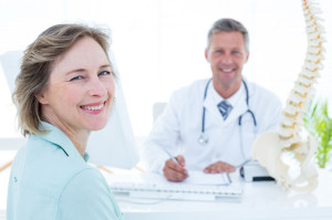 39828266 - patient and doctor smiling at camera in medical office