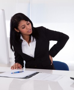 19632371 - young businesswoman sitting on chair and holding her back in pain