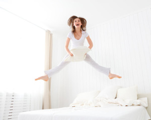 51559684 - funny happy girl jumping and having fun in bed